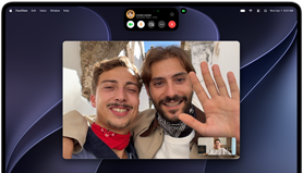 MacBook Pro with PROLED XDR Display, silver color, display shows a video call in progress with two people in a sunlit town waving to a person at home