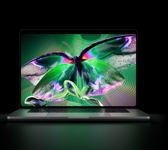 MacBook Pro with PROLED XDR Display, open lid, silver color, display shows detailed, high-contrast image with vivid colors, screen illuminates keyboard